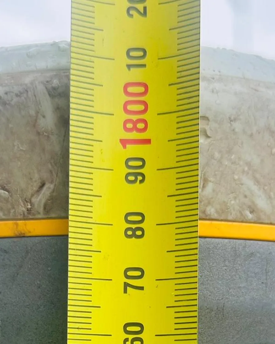 A tape measure held against a GNSS antenna to record its height